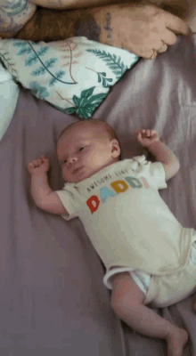 a baby wearing an awesome like daddy shirt