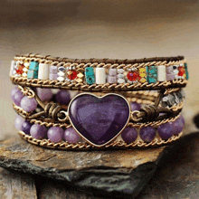 a bracelet with purple beads and a heart shaped stone