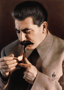 a man with a mustache is smoking a pipe with a match in his hand