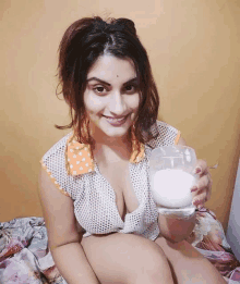 a woman is holding a glass of milk in her hand