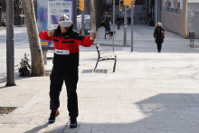 a man wearing a virtual reality headset stands in front of a billboard that says llum bcn