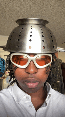 a man wearing a strainer on his head and sunglasses