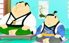 two fat men in samurai costumes are sitting on a mat .