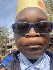 a boy wearing a burger king hat and sunglasses