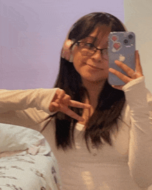 a girl taking a picture of herself in a mirror with an apple phone