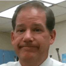 a man in a white shirt and tie is making a face .