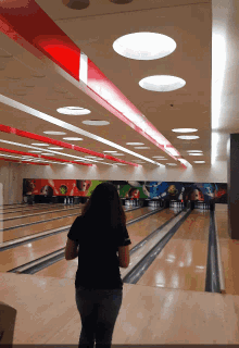 a woman is standing in a bowling alley with a mural on the wall that says ' coca cola '