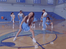 a group of cheerleaders are stretching on a basketball court in front of a banner that says ' jacksonville '