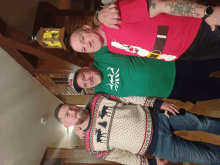 three men posing for a picture with one wearing a green shirt that says ' i love you '