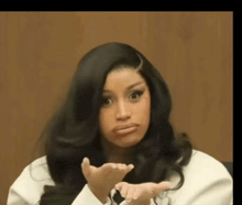 a woman with long black hair is making a funny face with her hands