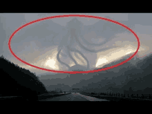 a giant monster is flying over a highway in the sky .