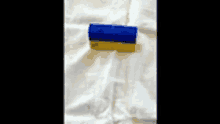 a blue and yellow box on a white cloth with the letter a on it