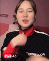 a woman wearing a red and black jacket with the number 2nd 46 on the bottom