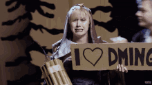 a woman holding a cardboard sign that says " i love dming "