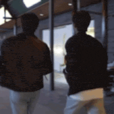 a blurry picture of two men walking on a sidewalk