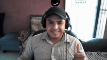 a man wearing headphones gives a thumbs up