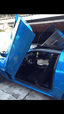 a blue car with its doors open and the hood up