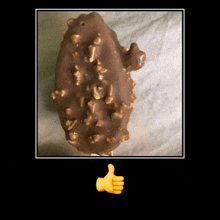 a close up of a chocolate covered ice cream bar next to a thumbs up sign