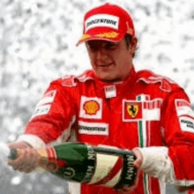 a man in a red ferrari uniform is pouring a bottle of champagne .