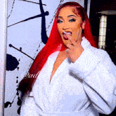a woman with red hair is wearing a white robe and has a ring on her finger