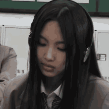 a girl wearing headphones is sitting in a classroom .