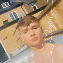 a young man without a shirt is taking a selfie in a pool .