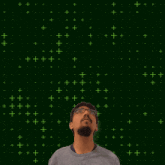 a man with glasses stands in front of a green background with the number 20 on it