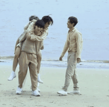 a man is carrying another man on his shoulders on a beach