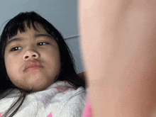 a little girl with long hair looks at the camera