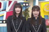 two girls are standing next to each other in front of a sign that says ov