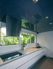 a kitchen with a blue ceiling and white cabinets has a stove top oven