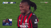 a soccer player wearing a red and black jersey with the number 10 on it