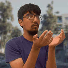 a man wearing glasses and a purple shirt is clapping