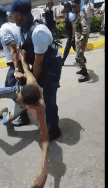 a shirtless man is being carried by a police officer