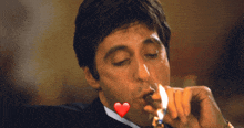 a man in a suit is smoking a cigar with a heart on his face