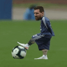 a man with a tattoo on his leg is kicking a soccer ball on a soccer field .