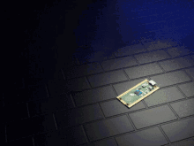 a piece of electronic equipment is laying on a brick floor