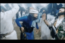 a man in a blue shirt and white hat is dancing in a crowd