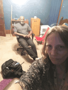 a man sits in a chair next to a woman wearing a lanyard that says ' i love you '