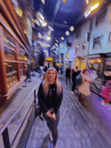 a blurry photo of a woman walking down a cobblestone street at night