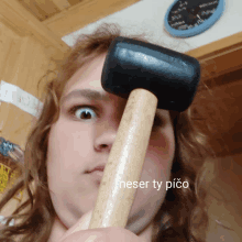 a woman is holding a rubber mallet in front of her face and the words neser ty pico are below her