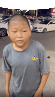 a boy wearing a grey shirt with the word fun on the front