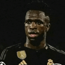 a soccer player is wearing a black shirt with adidas on it