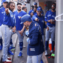 a group of blue jays baseball players are gathered in the dugout