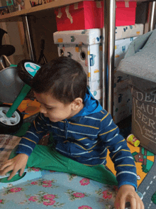 a little boy is playing with a toy on the floor in front of a laundry basket that says del lau ser