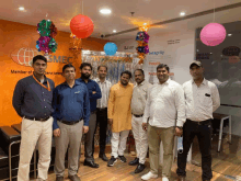 a group of men are posing for a photo in front of a sign that says smec