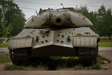 a large military tank is parked in the grass