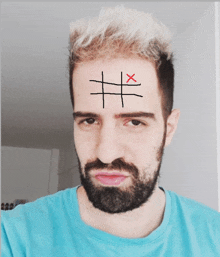 a man with a beard has a drawing of a cross on his forehead