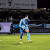 a soccer player is running on the field in front of a sign that says " ech gruppen as "