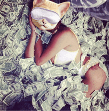 a woman is laying in a pile of money with a cat mask on